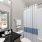 Model bedroom at our apartments for rent in North Dallas, featuring carpeted flooring and a view of the bathroom.
