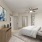 Model bedroom at our apartments for rent in North Dallas, featuring carpeted flooring and a view of the bathroom.