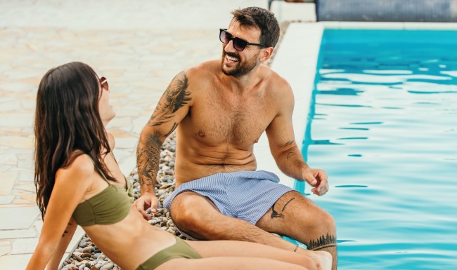 a couple sitting by a pool